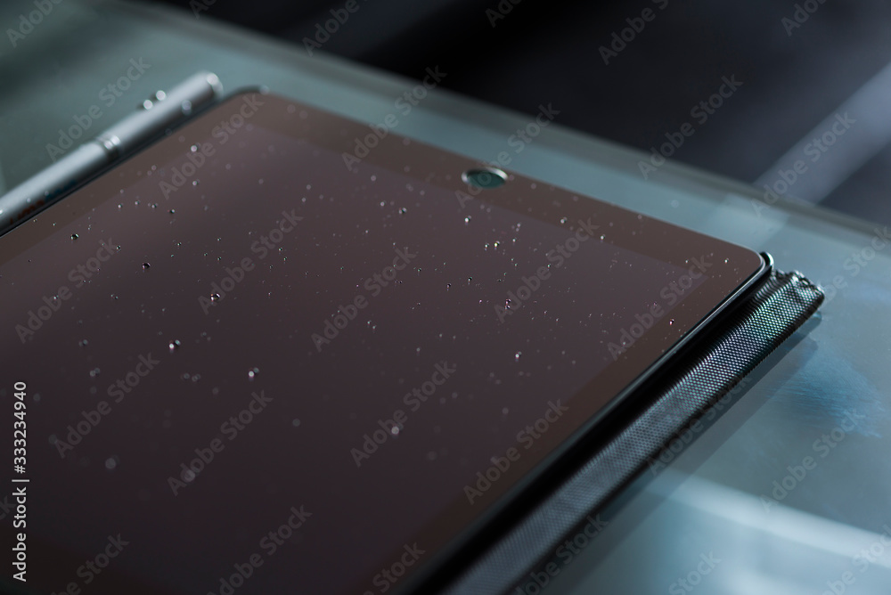 Closeup of a tablet screen with droplets on its surface after sneezing in the age of Coronavirus Closeup of a tablet screen with droplets on its surface after sneezing in the age of Coronavirus