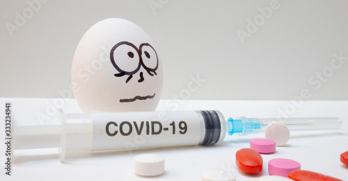 frightened egg face with tablets and syringes next to it photo