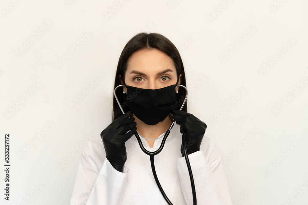 Female doctor in black protective medical mask and black gloves, a stethoscope on neck Female doctor in black protective medical mask and black gloves, a stethoscope on neck