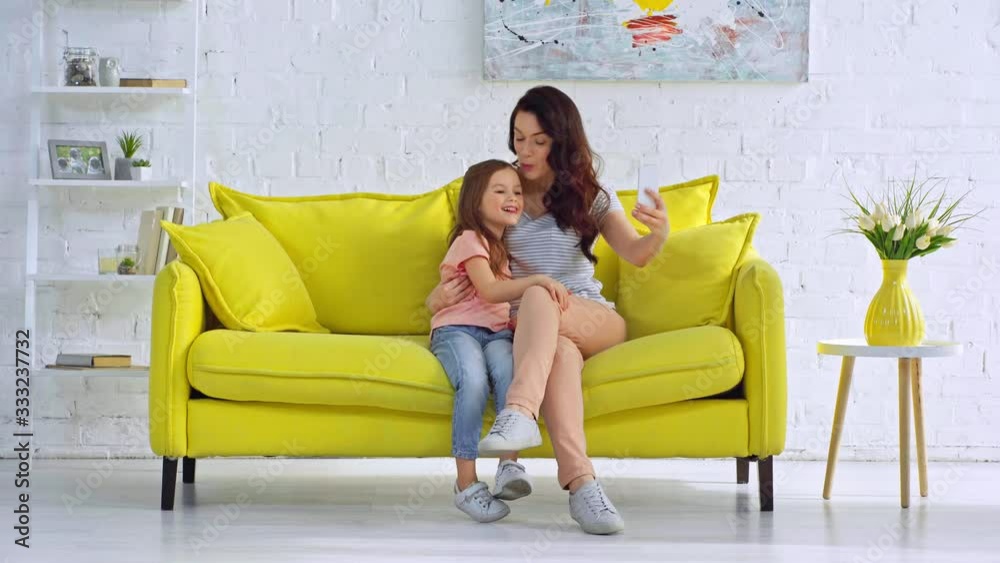 mother and daughter sticking out tongue while taking selfie