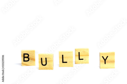 Bully word wooden object isolated white background and copy space - Bullying is the use of force, coercion, or threat, to abuse, aggressively dominate or intimidate. Do not do that concept