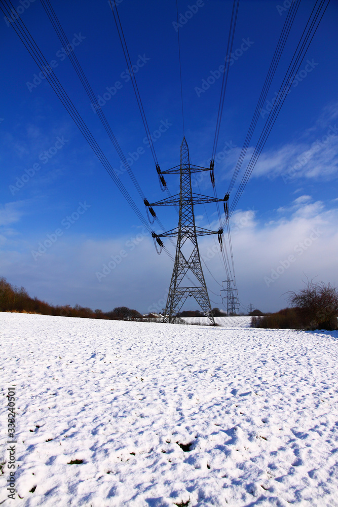 UK electricity pylons located in a snowy field UK electricity pylons located in a snowy field