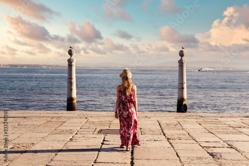 Young tourist traveling through beautiful sunny european city and looking at view, rear view