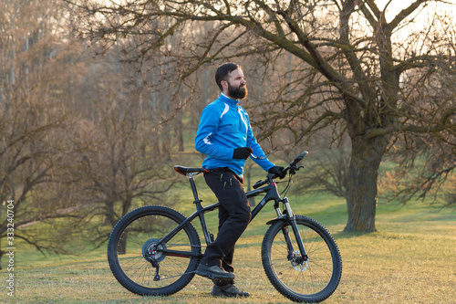 Cyclist in pants and fleece jacket on a modern carbon hardtail bike with an air suspension fork. The guy on the top of the hill rides a bike.