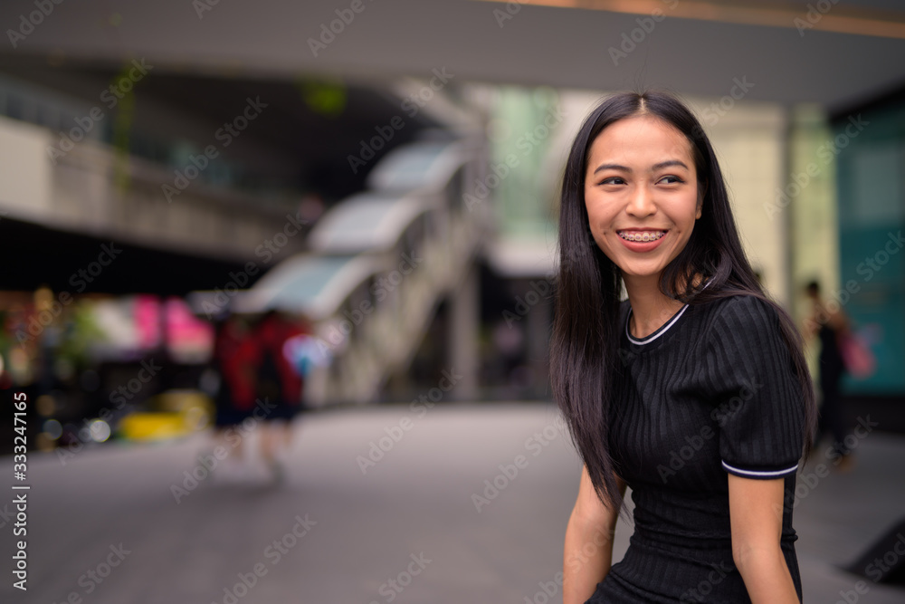 Happy young beautiful Asian tourist woman at the mall outdoors Happy young beautiful Asian tourist woman at the mall outdoors