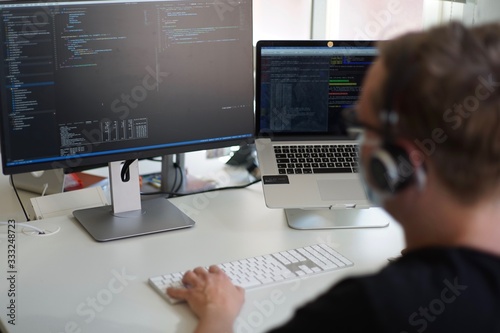 Real male web programmer coding javascript, php, symfony, react at work 