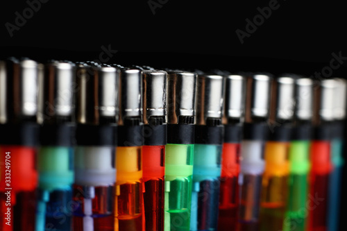 colored lighters on a dark background lined up in a straight line