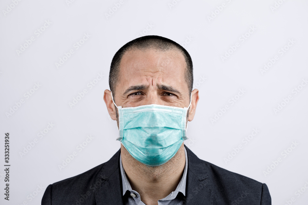 Uomo in giacca e camicia con mascherina protettiva, piange disperato , isolato su sfondo bianco Uomo in giacca e camicia con mascherina protettiva, piange disperato , isolato su sfondo bianco