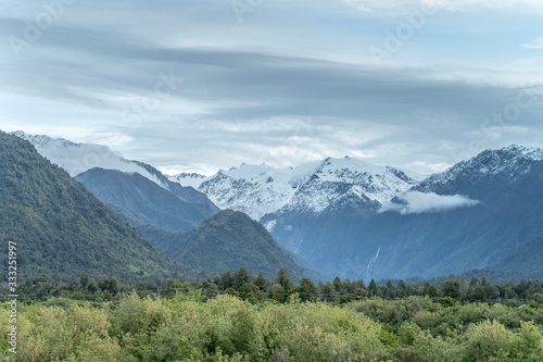 snowy Roon peak out of green forest at Franz Josef Glacier touristic village, West Coast, New Zealand © hal_pand_108