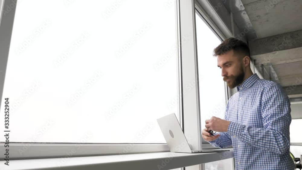young man tired from work taking off glasses and closing laptop