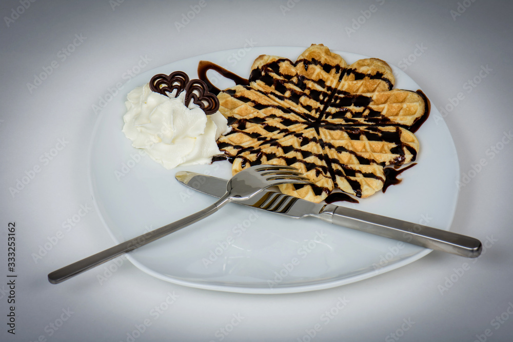 Fototapeta premium Waffles with chocolate and cream for a tasty desert.