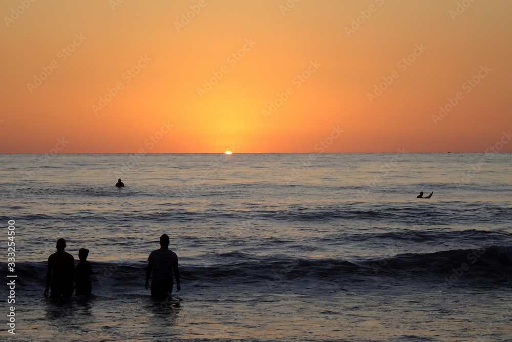Silhouette of people at sunset at the beach