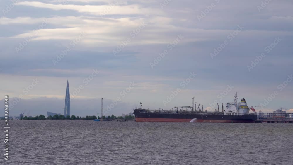 Large barge on the bay and water spills from it Large barge on the bay and water spills from it