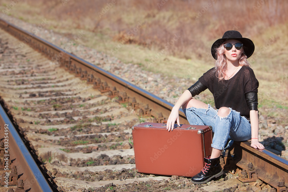 Young traveling woman with a suitcase on the railway Young traveling woman with a suitcase on the railway