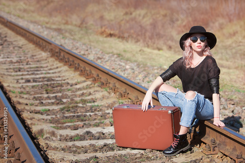 Young traveling woman with a suitcase on the railway