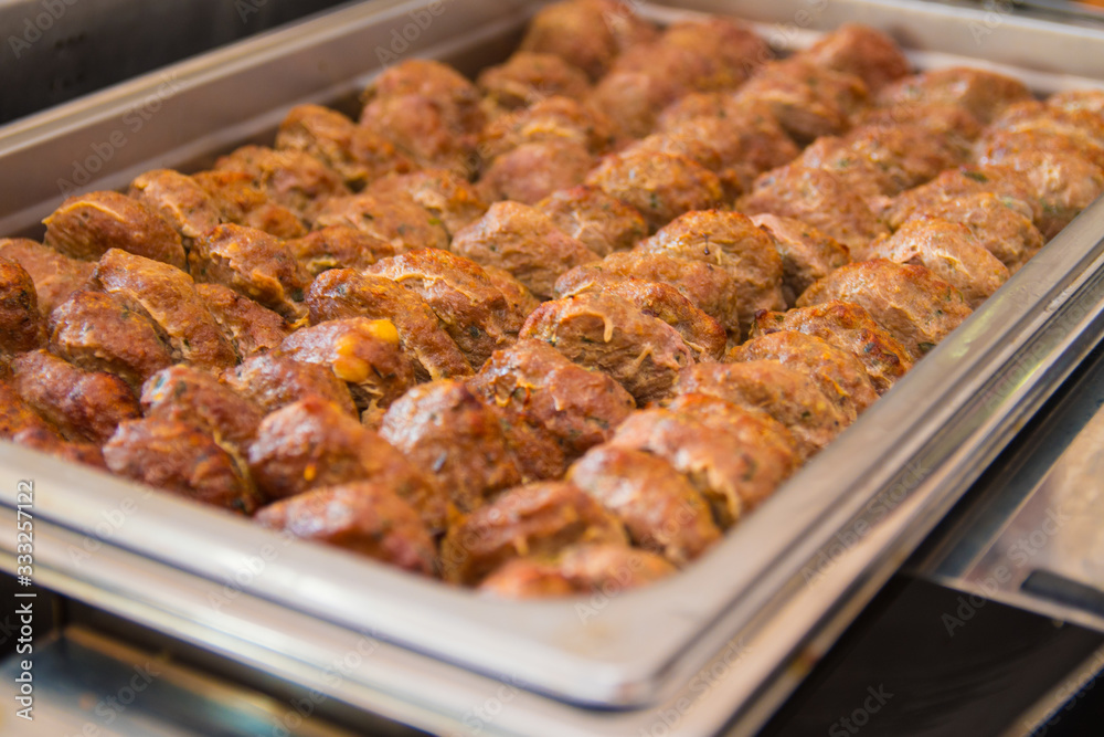 Fried meatballs with herbs in a hot catering baking food tray