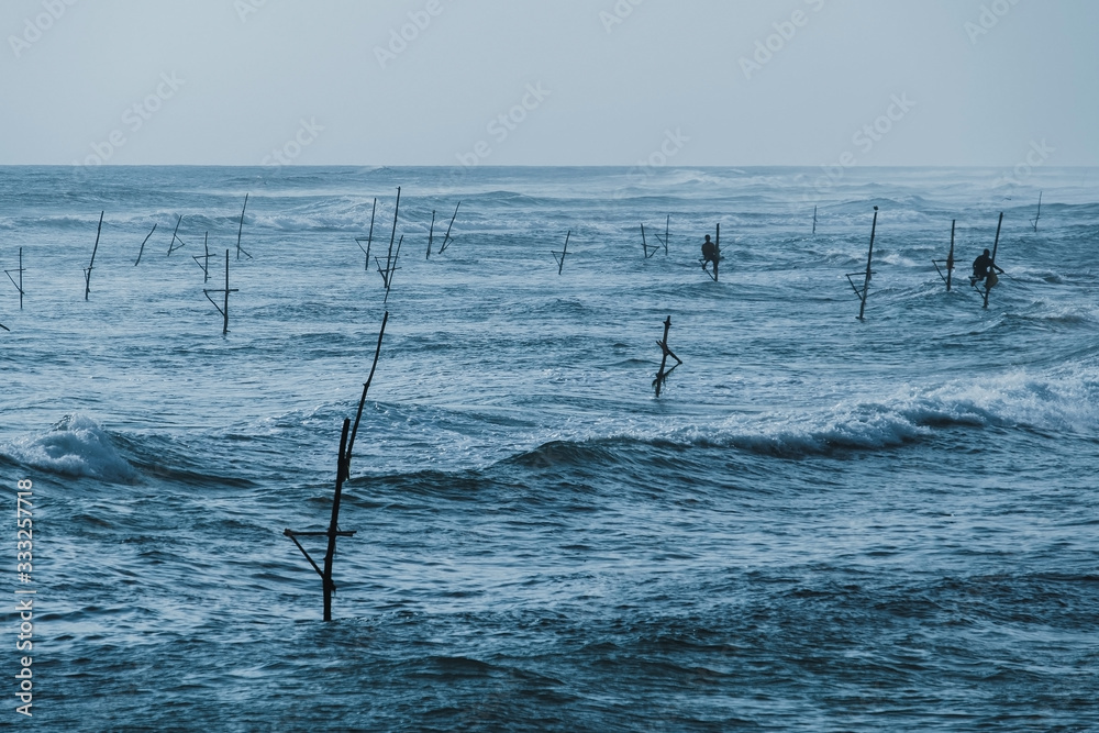 Traditional Stilt Fishermen in Sri Lanka Concept Traditional Stilt Fishermen in Sri Lanka Concept