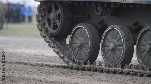 Moving catterpillar tracks of an armoured fighting vehicle on an exerise field 