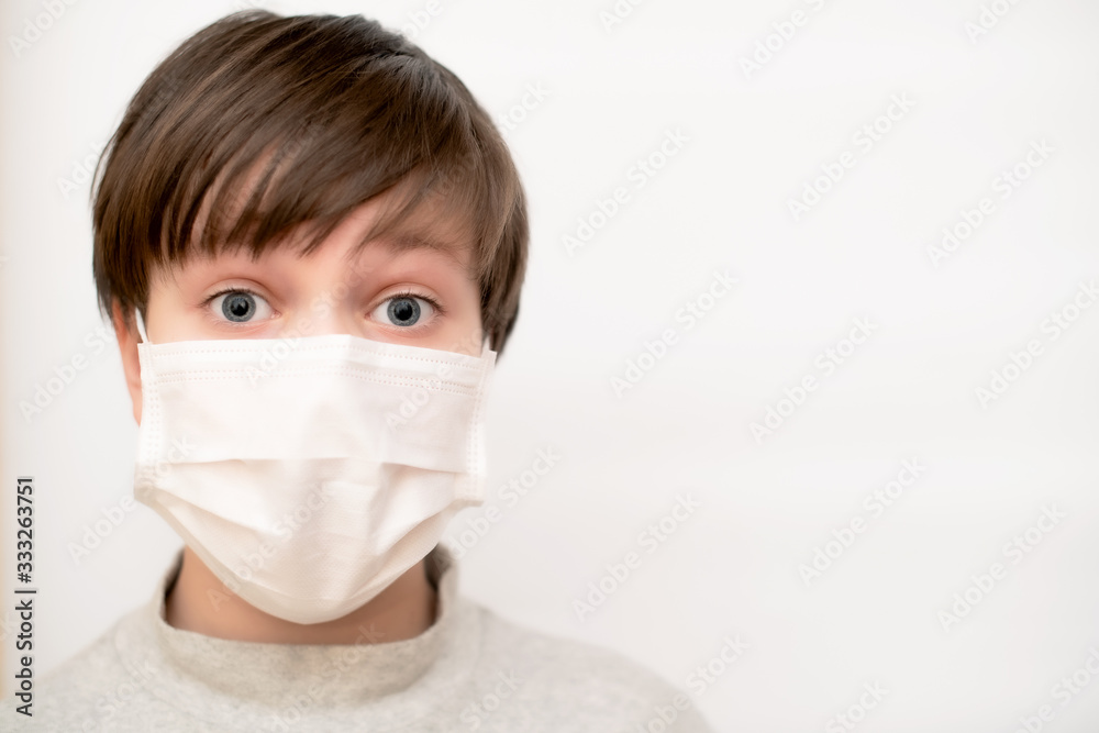 Boy close-up in a medical mask on a white background. The concept of protection, coronavirus and quarantine. Copy space. Boy close-up in a medical mask on a white background. The concept of protection, coronavirus and quarantine. Copy space.