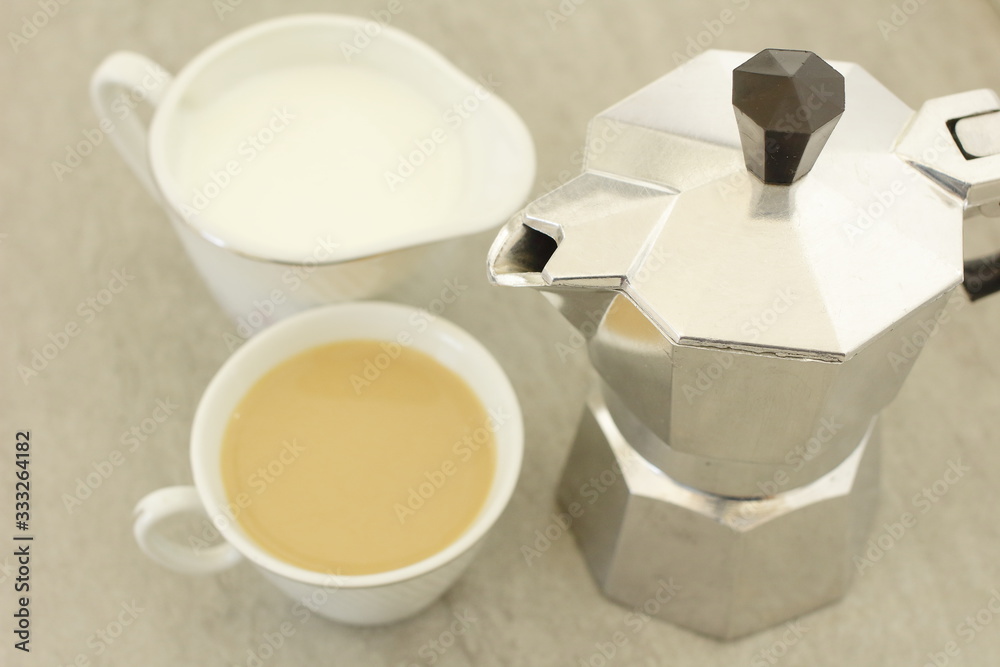 cafetera metálica junto a una taza de café y una jarra de leche pequeña,  leche, cafeína, mañana, madrugar, despertar, bebida Stock Photo | Adobe  Stock