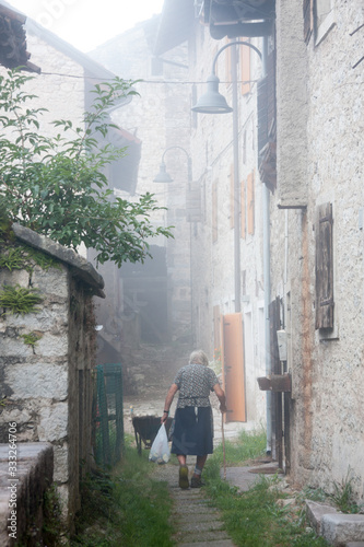 Erto e Casso, Pordenone, Friuli Venezia Giulia , Italy - August 29 2016:  an elderly woman walks the streets of Erto photo