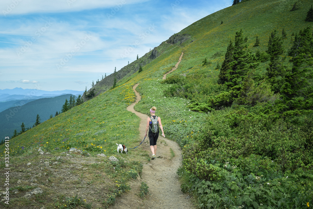 Woman hiking with small dog on epic trail in the Columbia River Gorge
