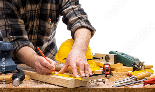 Close-up. Carpenter with pencil and carpenter's square draw the cutting line on a wooden board. Construction industry. Isolated on a white background.