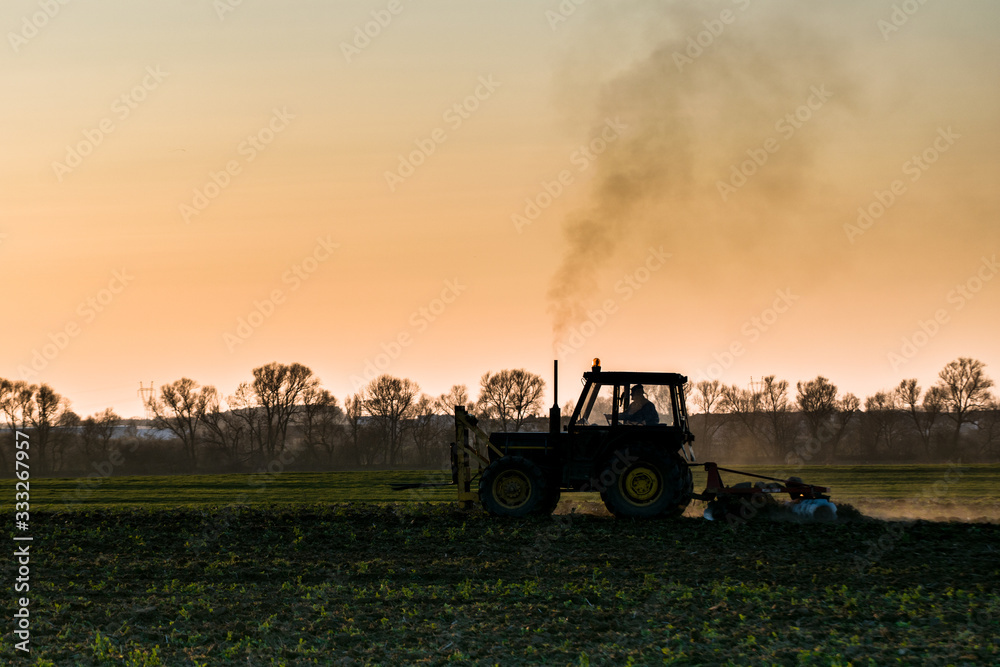 Obraz premium tractor farming sunset