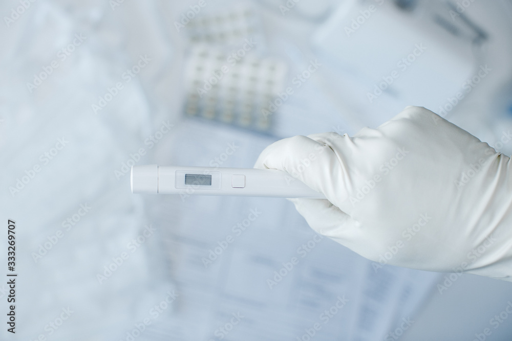 hand in gloves with a virus test on a background of a desktop in a hospital. coronovirus test in the laboratory, light background hand in gloves with a virus test on a background of a desktop in a hospital. coronovirus test in the laboratory, light background