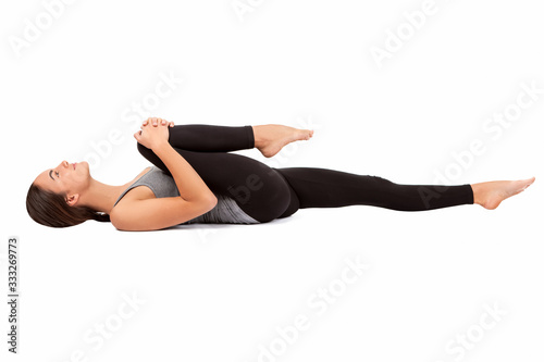 Beautiful girl on a white background does leg stretching exercise. Yoga.