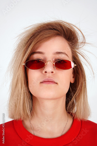 Vertical portrait - girl in red glasses, woman on a white background