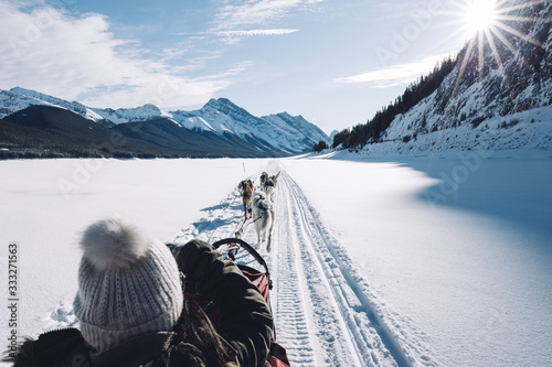 Woman sitting in a dog sled on a frozen lake, Spray Lakes, Kananaskis Country, Canadian Rockies, Alberta, Canada
