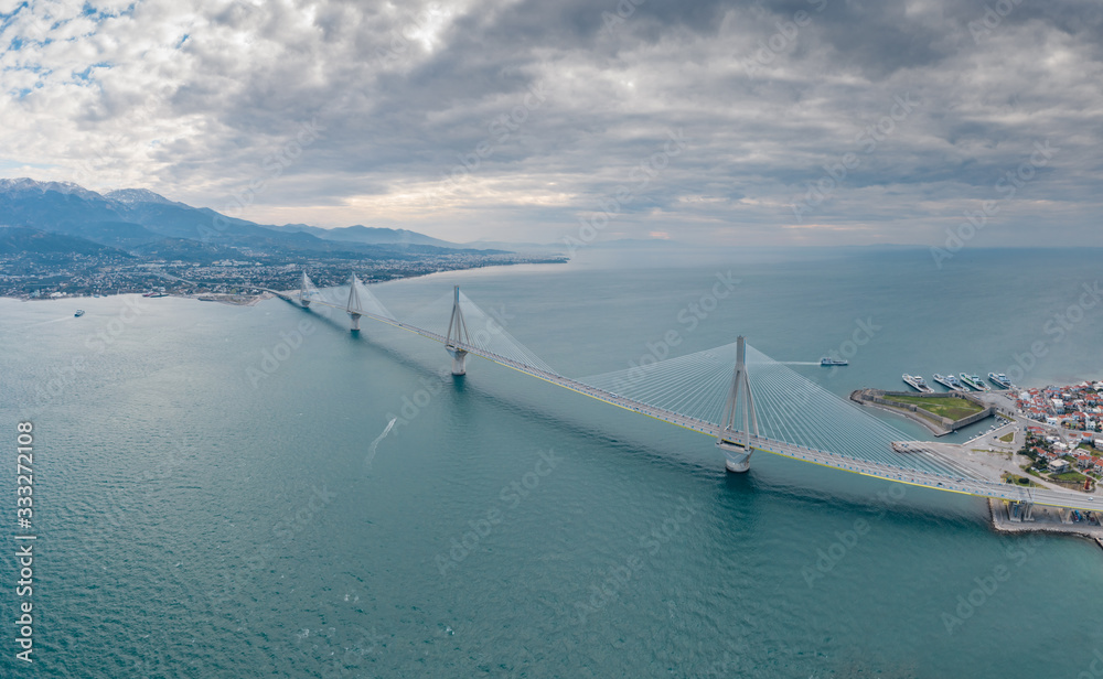 Aerial view of long cable-stayed Rio bridge in Greece at clouds weather, Ferry station