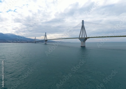 Aerial view of long cable-stayed Rio bridge in Greece at clouds weather, Ferry station