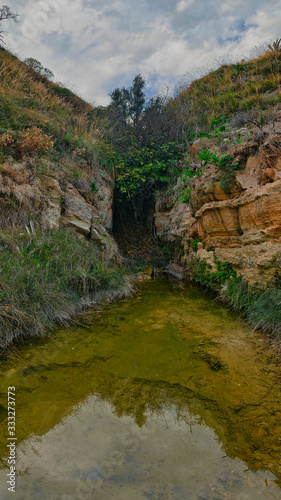 A source of crystal clear water between the sandstone walls. © Antonio