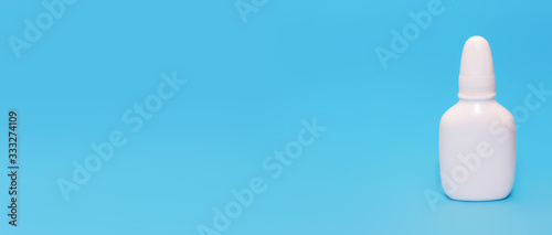 White medical bottle spray on a blue background.Copy space for text
