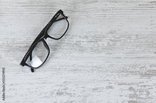 Stylish eyeglasses on wooden table