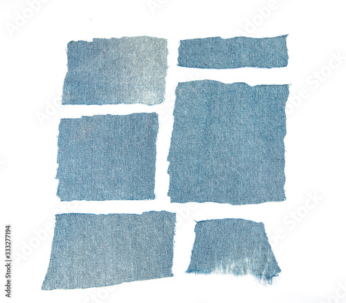 Destroyed torn denim blue jeans frayed flap patch fabric frame on white background