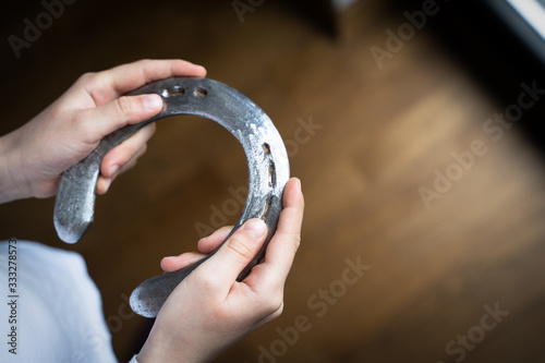 child holding a steel polished horshoe