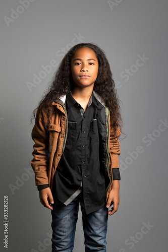 Portrait of stylish girl standing against gray background