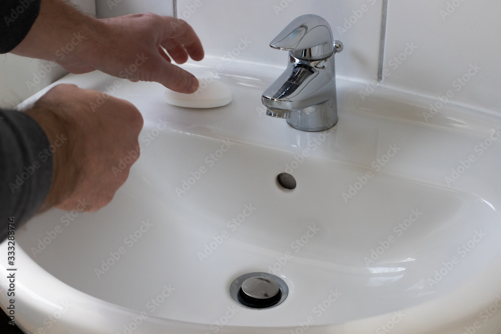 Detail of a Young male washing his Hands with Soap under running water in order to reduce infection Risk during corona Virus pandemic