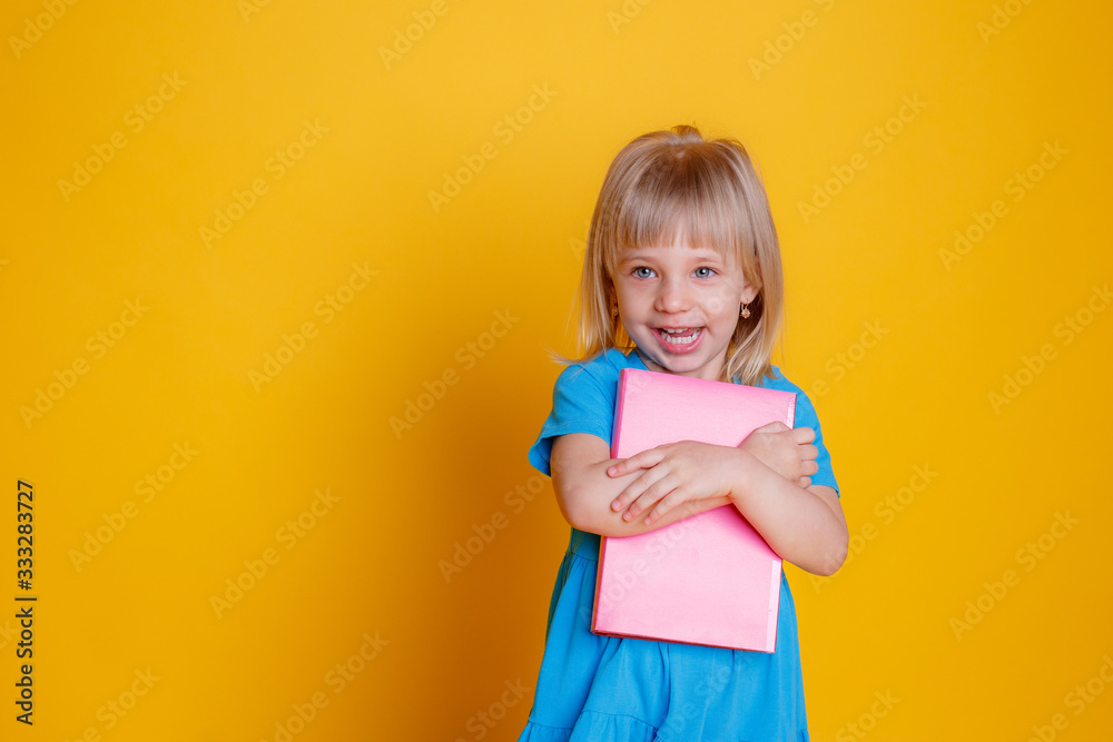 a little girl holds a book in her hands a little girl holds a book in her hands