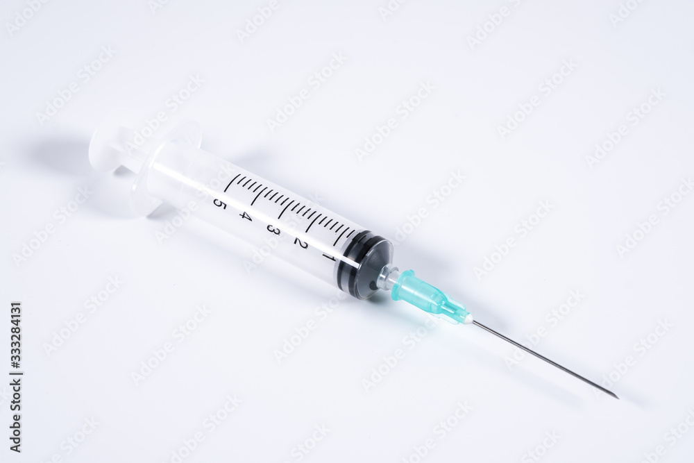 Syringe or injector on isolated white table surface Syringe or injector on isolated white table surface