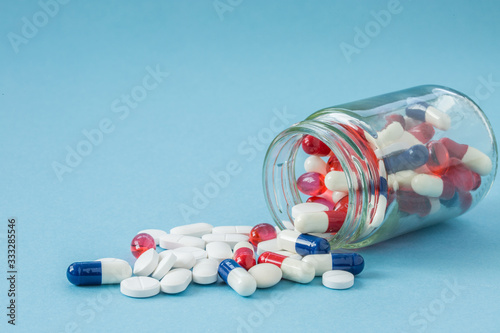 An upturned container full of medicine, pills, tablets, painkillers and medication with copy space