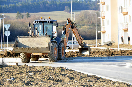 Wheel excavator works on ground shaping in front of the flathouse