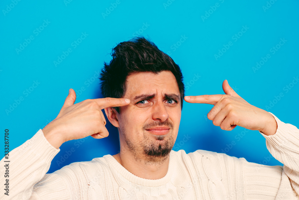 Closeup portrait of angry man gesturing with his finger against his temple, are you crazy? Closeup portrait of angry man gesturing with his finger against his temple, are you crazy?