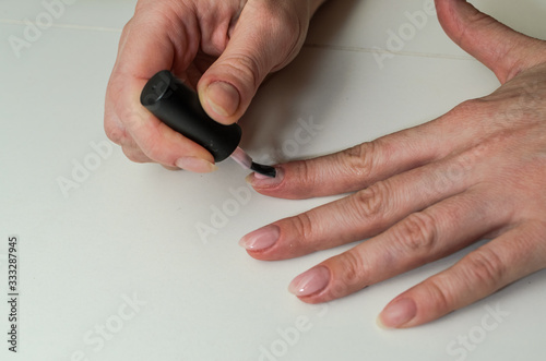 Woman paints nails with nail polish