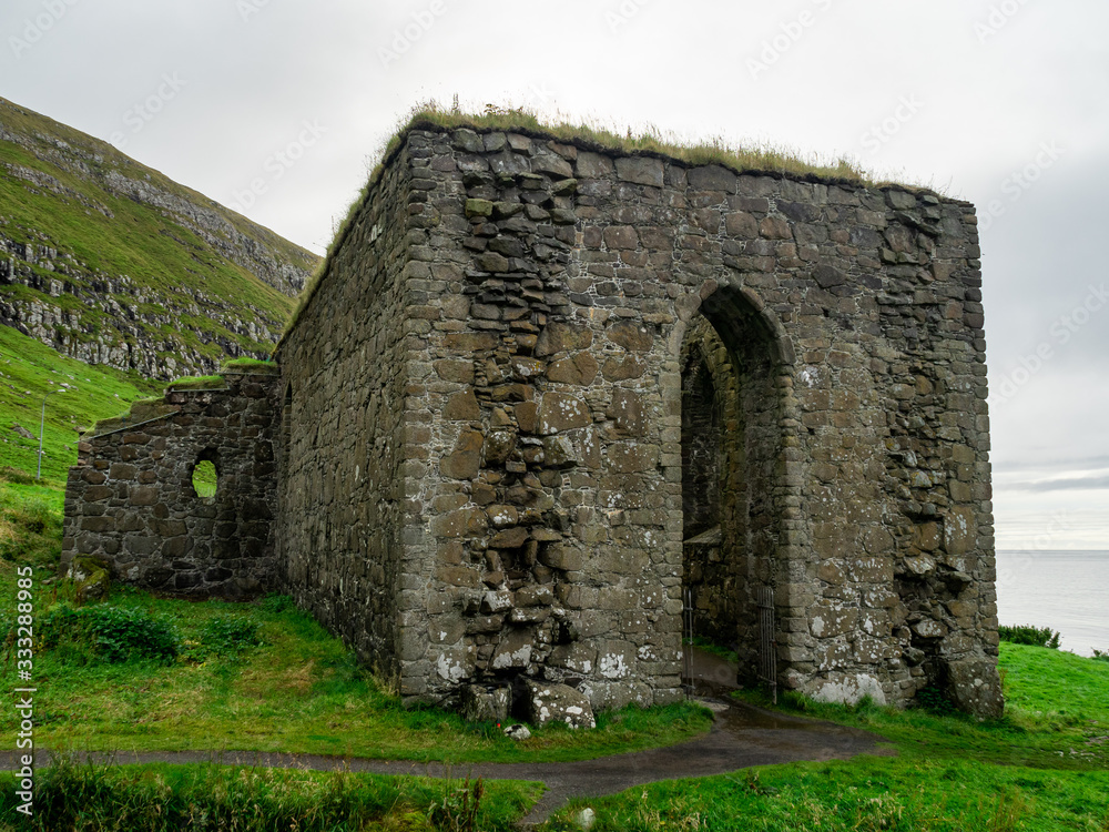 Faroe Islands. Kirkjubøur village. Old never roofed ruins of medieval cathedral.