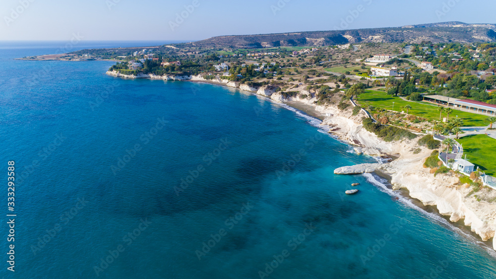 Aerial view of coastline and landmark big white chalk rock at Governor's beach, Limassol, Cyprus.The steep stone cliffs and deep blue sea waves crushing in coves at Kalymnos fish restaurant from above