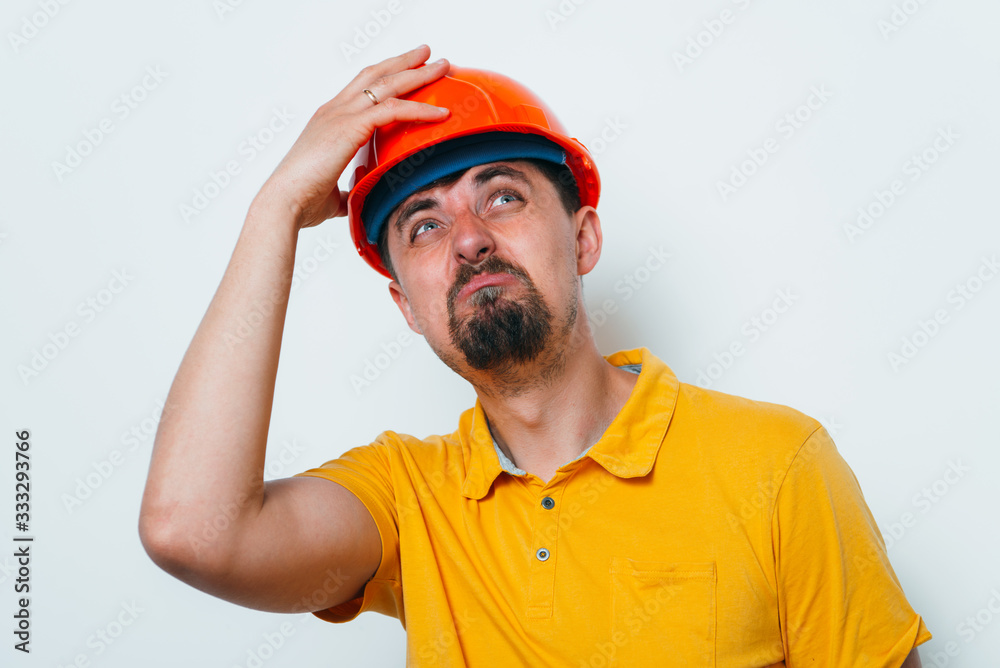 man close-up in helmet , holding his head by hand man close-up in helmet , holding his head by hand